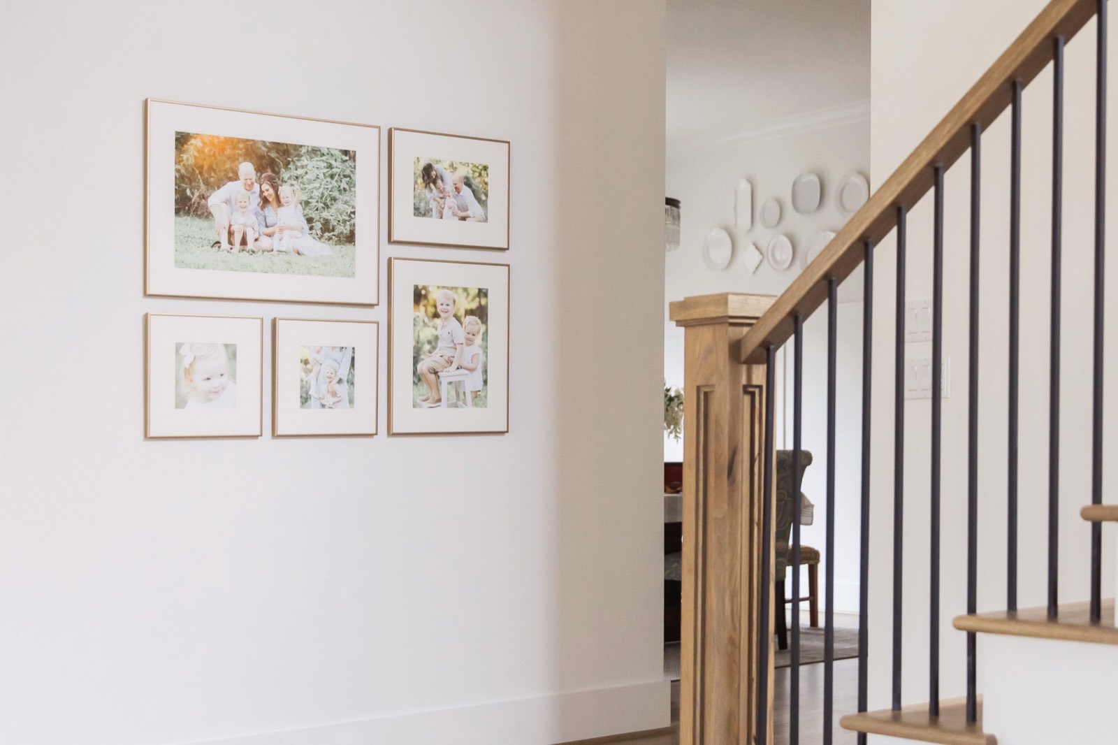 A gallery wall of framed portraits hanging in a family's home